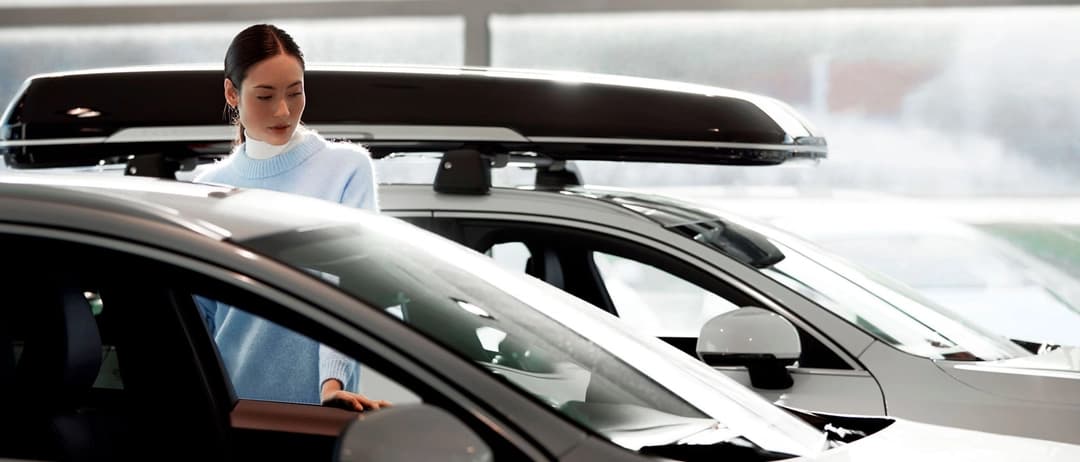 Pessoa ao lado de um Volvo estacionado na concessionária Volvo Pessoa ao lado de um Volvo estacionado na concessionária Volvo